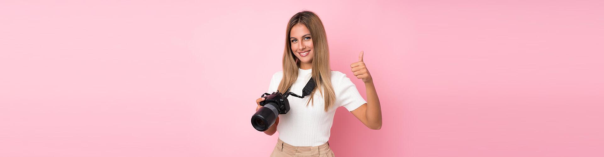 junge Frau im weißen T-Shirt mit Kamera um den Hals und in der Hand